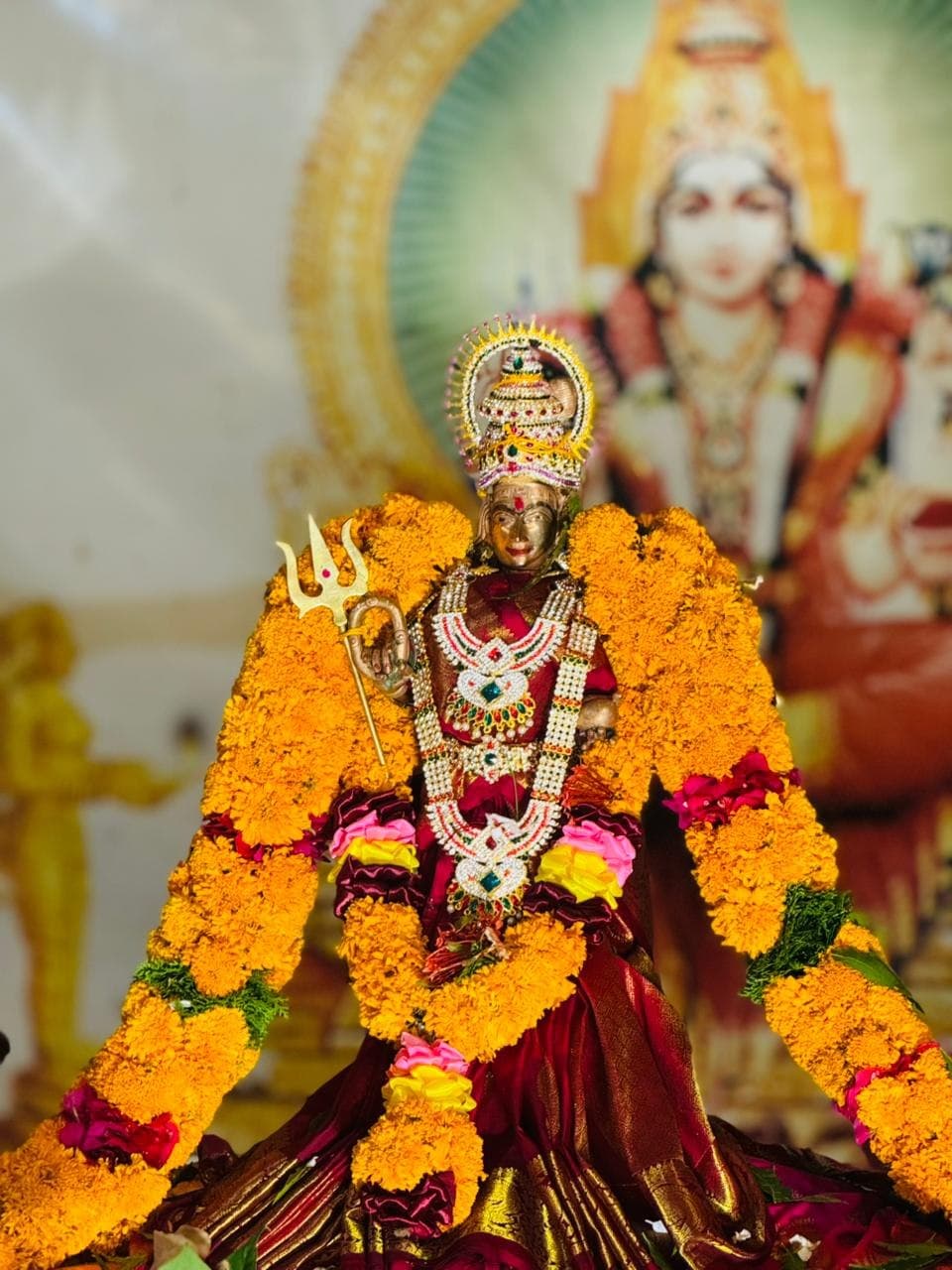 Sri Kannagi Amman deity richly decorated with marigold garlands and silk