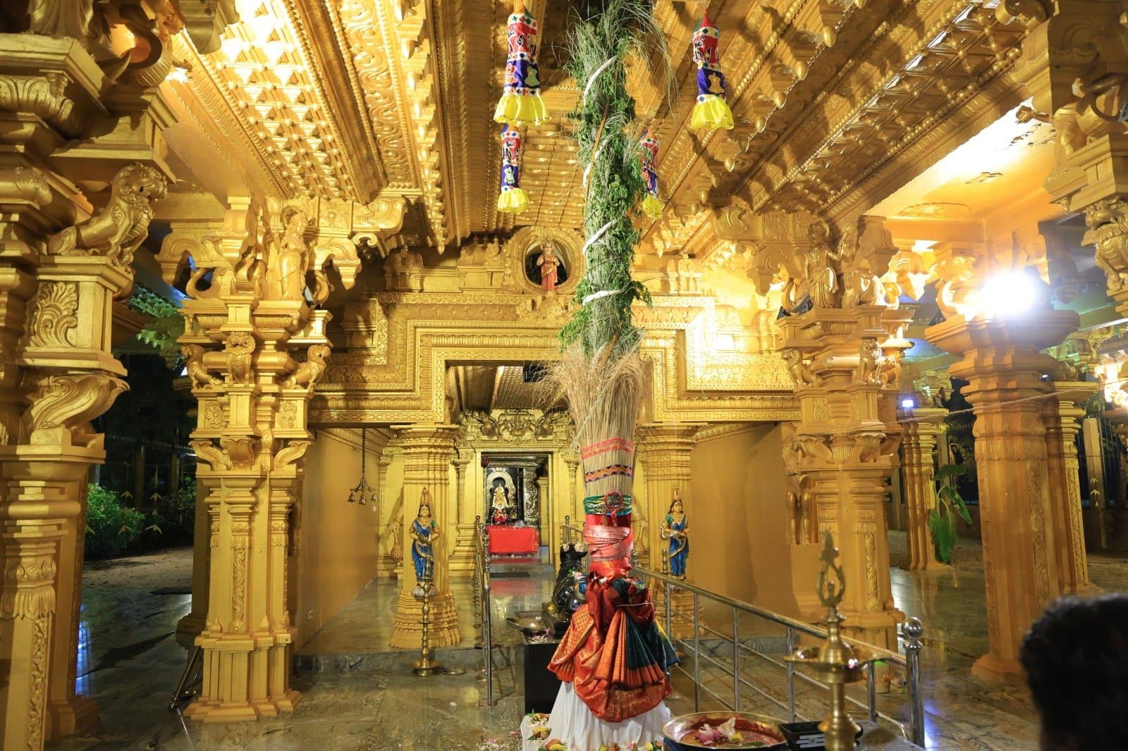 Interior of the temple mandapam with ornate golden pillars